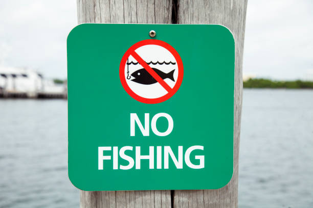 zaloguj się przed wodą, prosząc ludzi, aby nie łowili ryb. nie łowienie poza tym punktem. - no fishing zdjęcia i obrazy z banku zdjęć