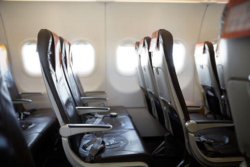 Side view of unoccupied commercial airline seats during 2020 travel ban and lockdown resulting from coronavirus pandemic.