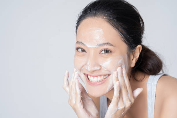 beautiful female asian wash face in studio - exfoliating scrub imagens e fotografias de stock