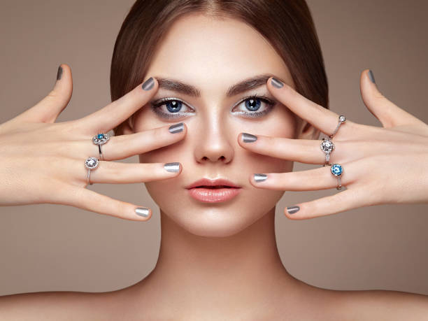 Fashion portrait of young beautiful woman with jewelry Fashion portrait of young beautiful woman with jewelry. Brunette girl. Perfect make-up.  Beauty style woman with diamond accessories fingernail photos stock pictures, royalty-free photos & images
