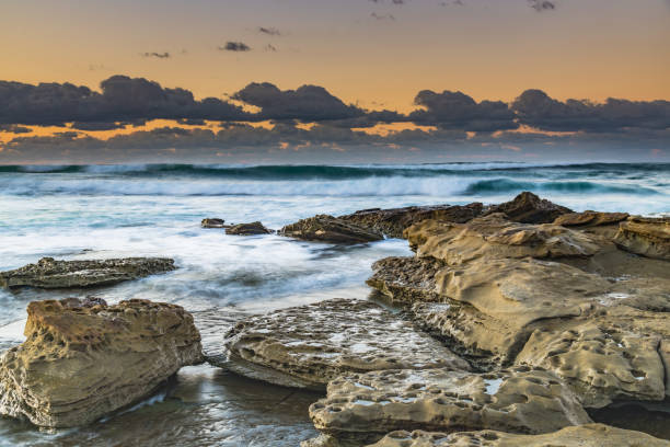 istock Sunrise seascape with rocks and low cloud bank 1265400060