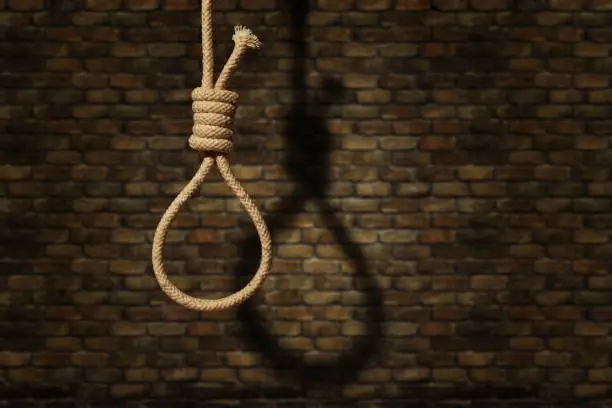 Photo of suicide concept. noose with shadow on dark wall background