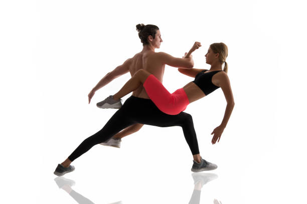 istock Improving flexibility through pilates training. Couple of athletes training together isolated on white. Athletic training. Physical training activity and sport. Fitness 1265410123