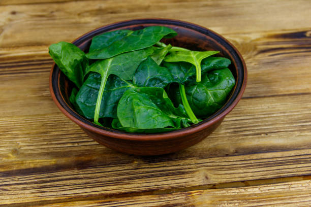 istock Fresh green spinach leaves in bowl on a wooden table 1265424729
