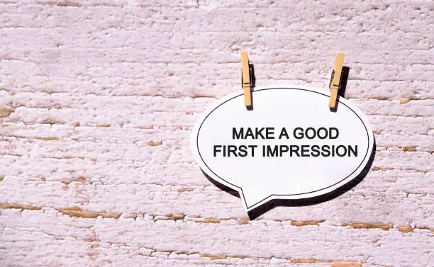 Photo of Make a good first impression on a white sheet with wooden pins