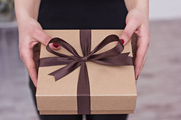 istock Female hands hold a  box with a gift. 1265429599