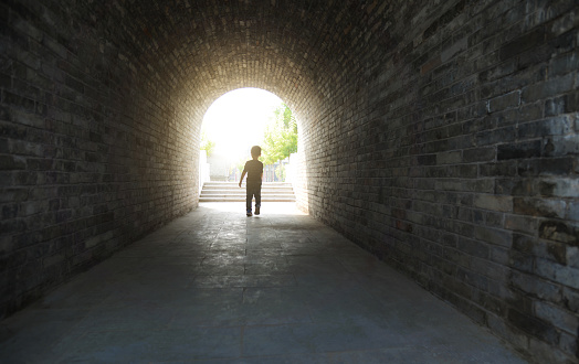 Little boy running through the tunnel