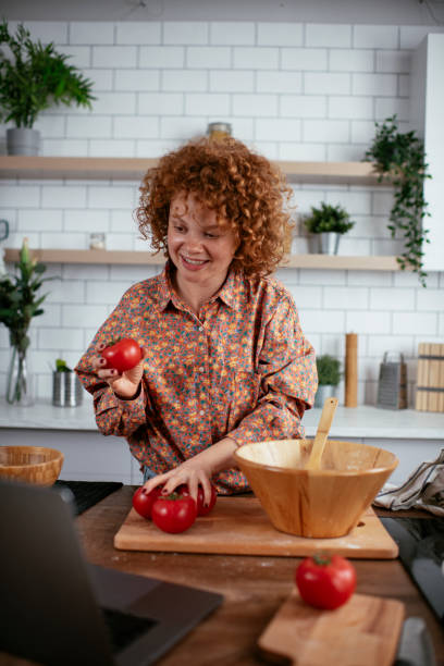 istock Young woman cooking while having video call. 1265429716