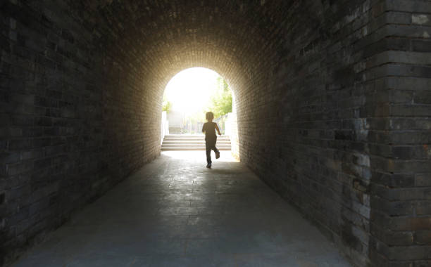 istock Little boy running through the tunnel 1265429750