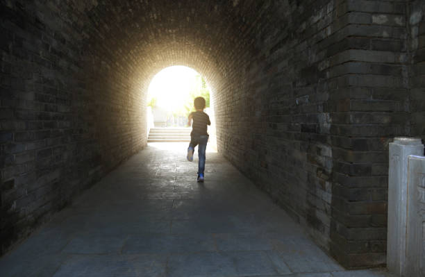 istock Little boy running through the tunnel 1265429751