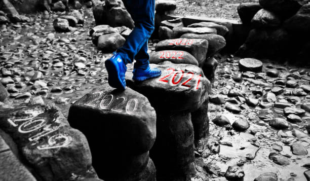 petit garçon traversant des tremplins avec le numéro 2019 à 2023 - stepping stone stone stepping footpath photos et images de collection