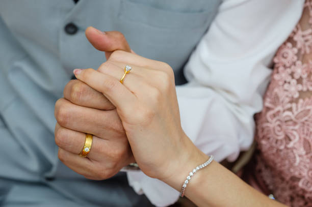 istock wedding rings together in hands 1265435428