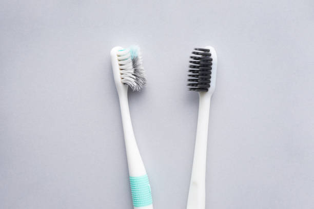 New and old toothbrushes on a gray background, close-up, flat lay. stock photo