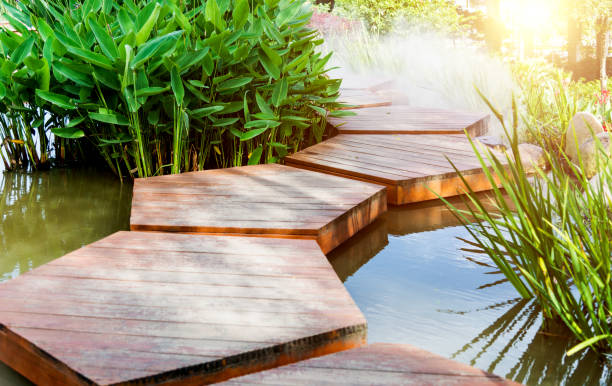 A charming wooden bridge spans a tranquil pond in a serene garden.