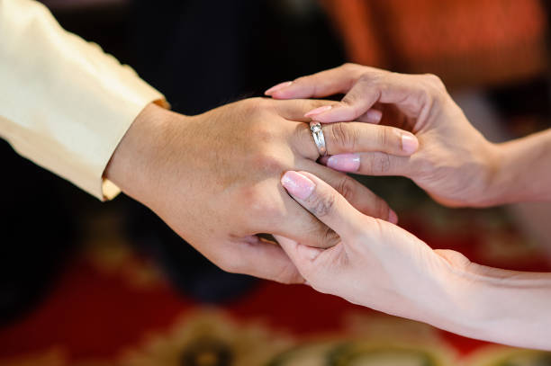 istock wedding rings together in hands 1265436539