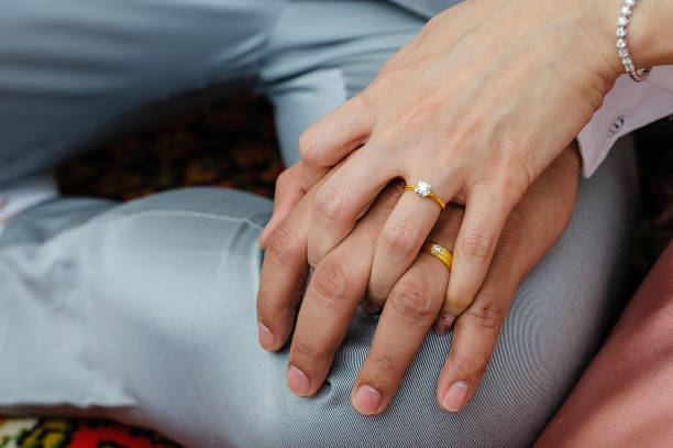istock wedding rings together in hands 1265436861
