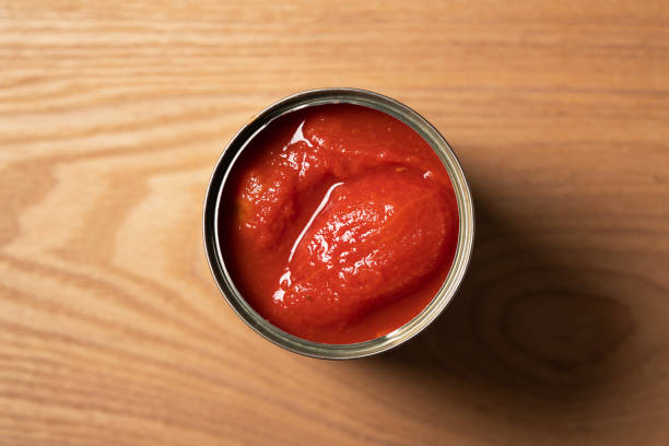istock Whole tomato cans on a wooden background 1265440757