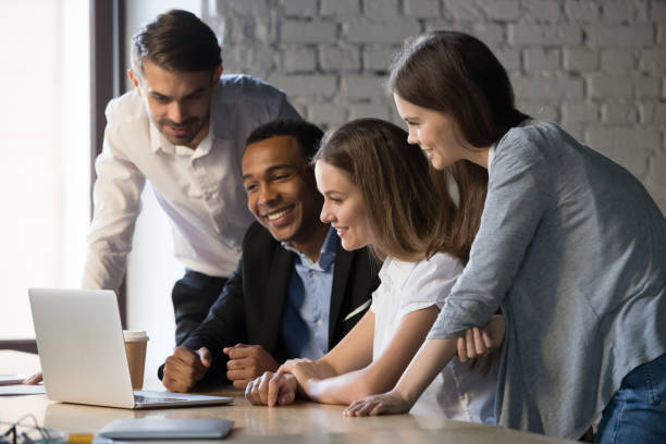istock Smiling diverse employees team watching webinar on laptop together 1265464690