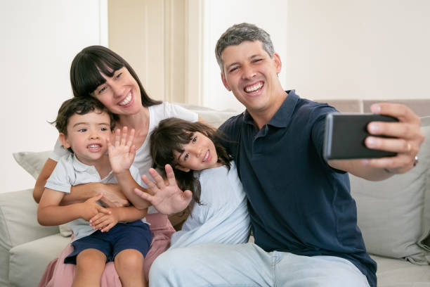 istock Happy parents hugging adorable kids 1265465080