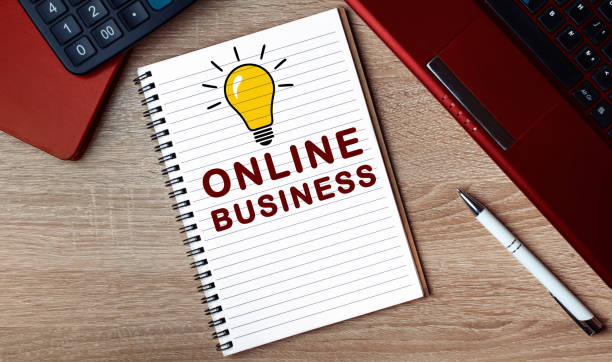 istock Notebook with text ONLINE BUSINESS. Notebook on desk with laptop and a pen. 1265467885