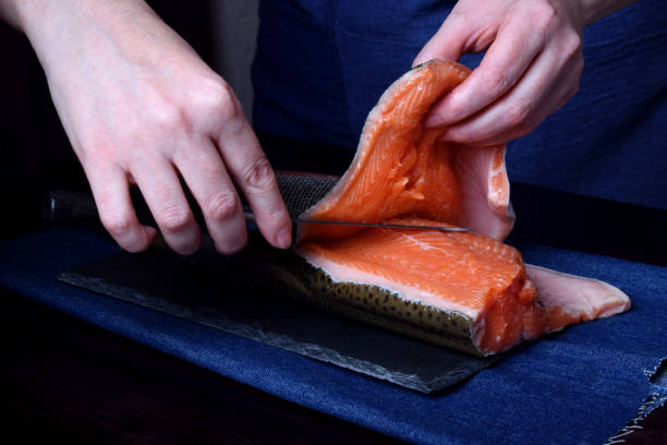 istock Cook is cutting carcass of a red fish with a knife 1265467977