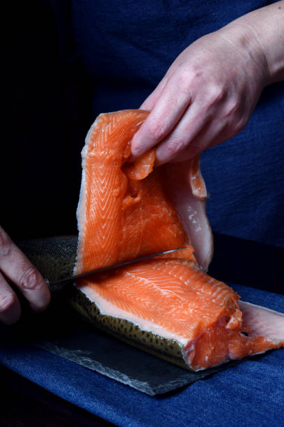 istock Cook is cutting carcass of a red fish with a knife 1265467986