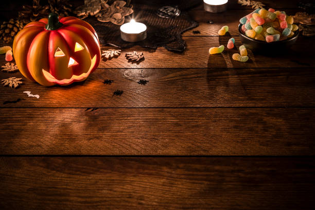 istock Jack-o-Lantern pumpkin with copy space on a rustic wooden table 1265468206
