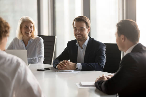 istock Friendly employees laughing at company briefing, successful negotiation 1265469976