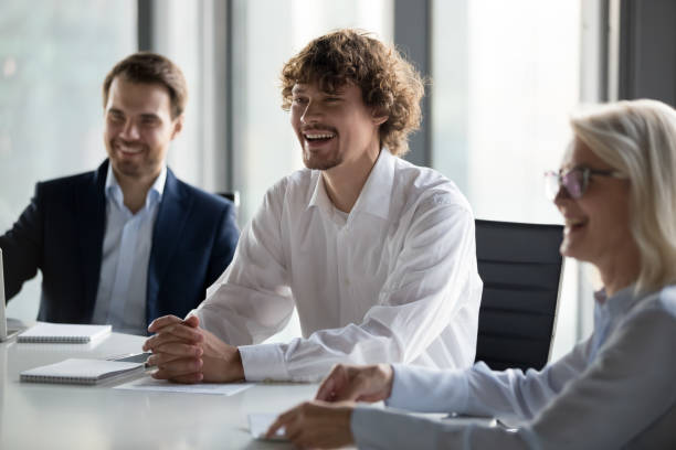 istock Friendly employees, colleagues having fun conversation at company briefing 1265469978