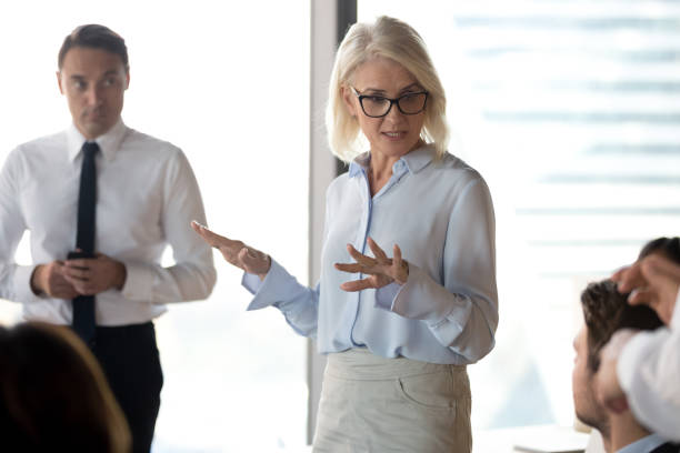 istock Mature businesswoman, business coach holding briefing, explaining project 1265470594