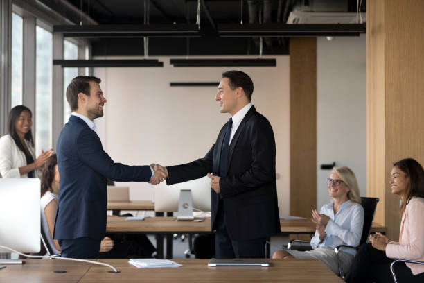 istock Executive manager shaking hand of successful employee at meeting 1265470990