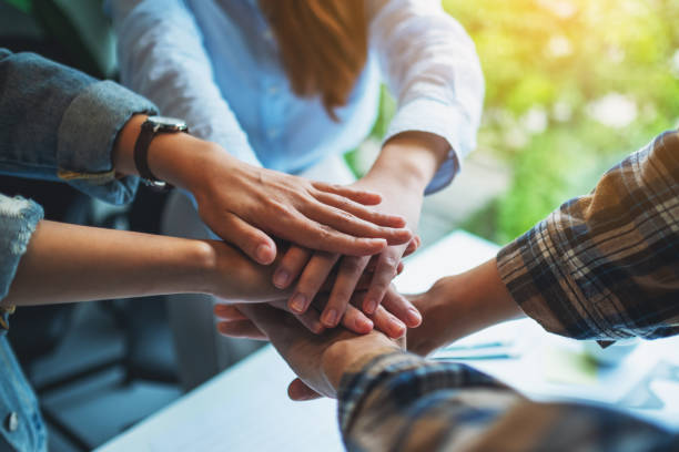 istock business team standing and joining their hands together in office 1265476026