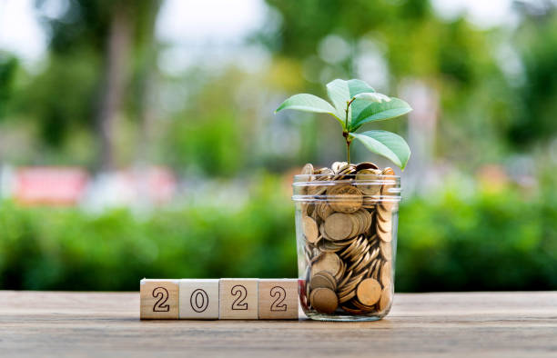 istock Coin jar and number 2022 on the table 1265483435