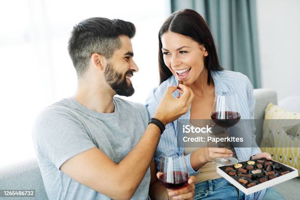 Woman Couple Man Happy Happiness Love Young Chocolate Praline Eating Together Romantic Boyfriend Girlfriend Stock Photo - Download Image Now