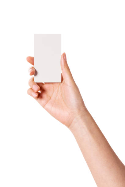 istock woman hand holding a blank namecard front view isolated on white. 1265498199