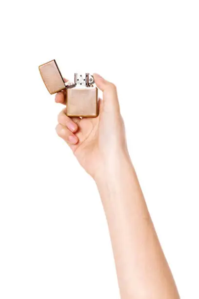 Photo of woman hand holding a zippo lighter isolated on white.