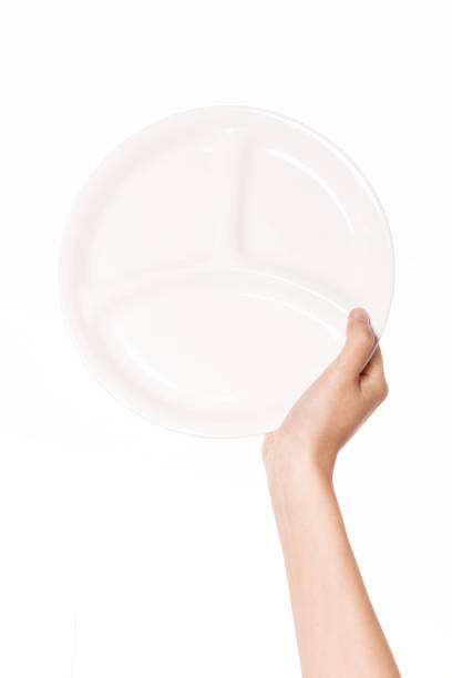 istock woman hand holding a ceramic dish vertical isolated on white. 1265499296
