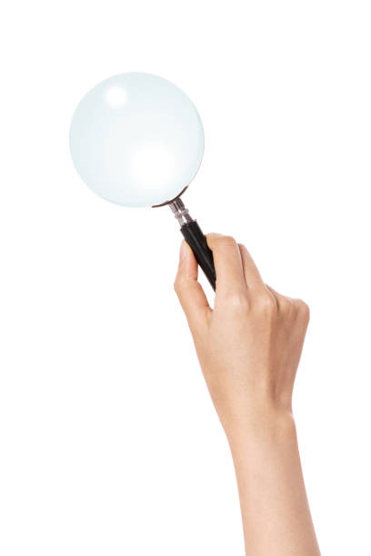 istock woman hand holding a magnifier isolated on white. 1265500923