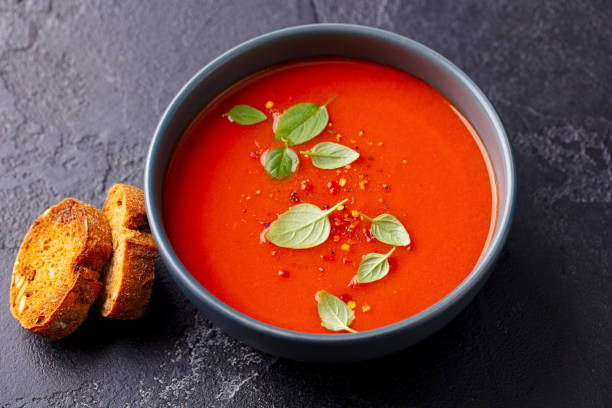 그릇에 바질 토마토 수프. 회색 배경. 닫습니다. 맨 위 보기입니다. - tomato soup red basil table 뉴스 사진 이미지
