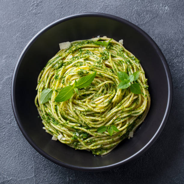 istock Pasta spaghetti with pesto sauce in black bowl. Grey background. Top view. 1265508146