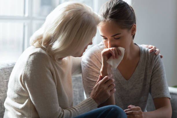 Caring elderly mom comfort adult depressed daughter Loving elderly mother hug crying millennial daughter show support and care after relationships breakup, supportive senior 60 woman embrace cuddle grownup child feeling depressed, having life problems wiping tears stock pictures, royalty-free photos & images