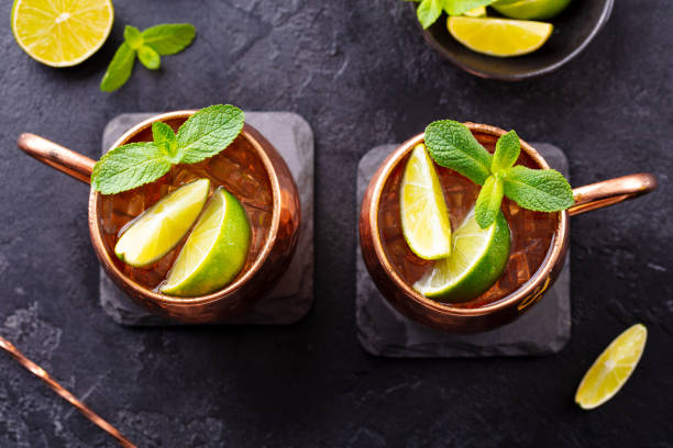 istock Moscow Mules cocktail with ginger beer, vodka, lime and mint. Grey background. Close up. Top view. 1265518547