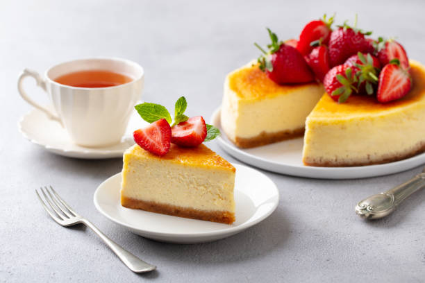cheesecake dessert con fragole fresche e tazza di tè. sfondo grigio. - tea cakes foto e immagini stock