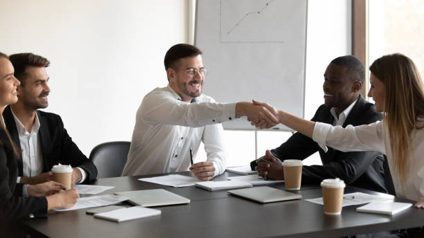 istock Smiling diverse business partners handshake greeting at meeting 1265522940
