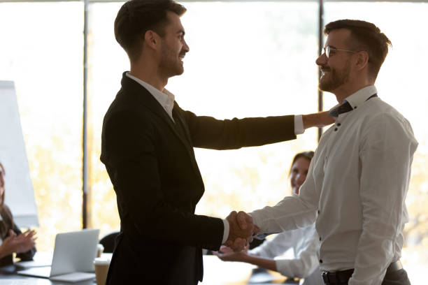 istock Smiling employer handshake male worker greeting with success 1265522978