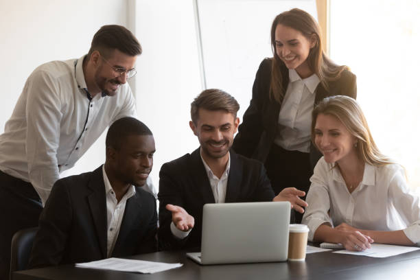 istock Smiling diverse employees cooperating in office using laptop 1265524039