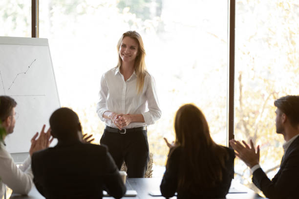 istock Diverse employees applaud greeting female speaker at meeting 1265525637