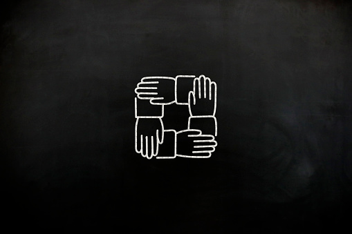 Four hands icon on blackboard