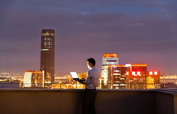 istock Businessman standing on the rooftop and using laptop 1265545335