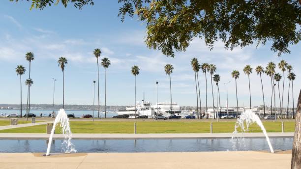 Fountain in waterfront city park near San Diego county civic center in downtown, California government authority, USA. Pacific ocean harbour, embarcadero in Gaslamp Quarter. Palms and grass near pier. fuente en el parque de la ciudad frente al mar cerca del centro cívico del condado de san diego en el centro de la ciudad, autoridad gubernamental de california, ee. uu. puerto del océano pacífico, embarcadero en el barrio de gaslamp. palmas y hierba ce